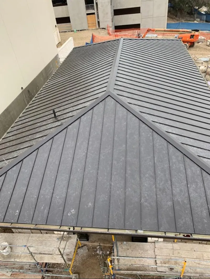 Commercial metal roof construction with crane equipment in Millbrook